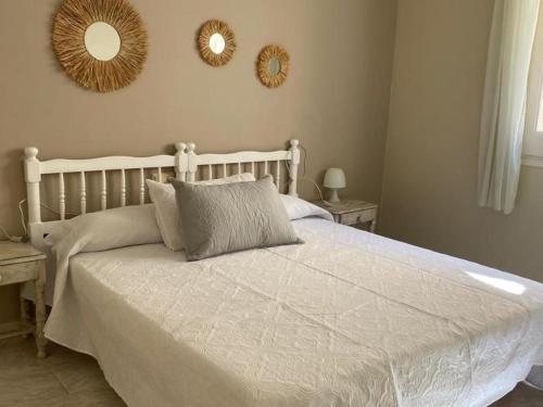 a bedroom with a white bed with two mirrors on the wall at INNOUTHOME APARTAMENTO CON WIFI y AA_BALMES I in L'Ametlla de Mar