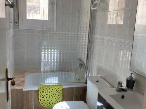 a bathroom with a tub and a toilet and a sink at INNOUTHOME APARTAMENTO CON WIFI y AA_BALMES I in L'Ametlla de Mar