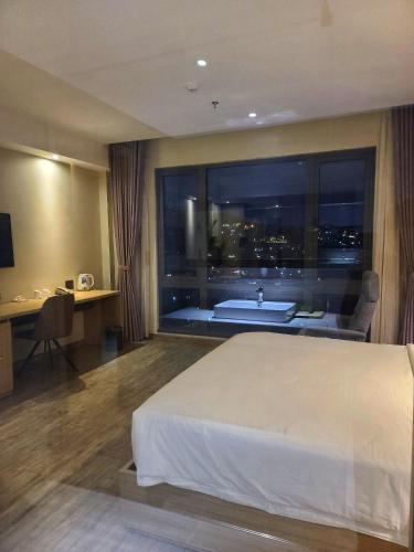 a hotel room with a bed and a bath tub at The Luxe Da Lat in Da Lat