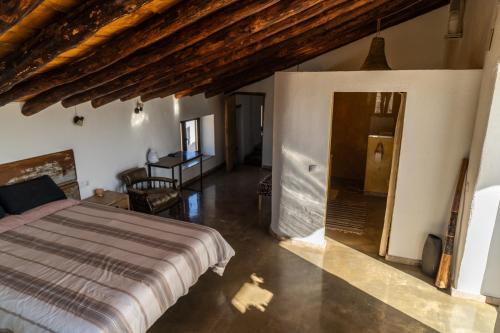 um quarto com uma cama e uma mesa num quarto em Cortijo Los Llanos em Huéscar