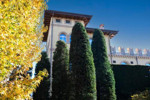 a building with a bunch of trees in front of it at Accomodation Hotel Castello Il Codirosso in Cesate