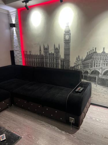 a black couch in a room with a picture of big ben at Кинотеатр Ватан in Dushanbe