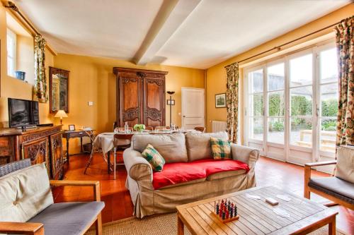 uma sala de estar com um sofá e uma mesa em La Rabouillère - House in Omaha Beach em Commes