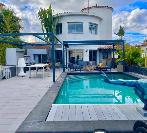 una casa con piscina frente a una casa en Medes 15 - Magnifica Villa con piscina privada y a en Ampuriabrava