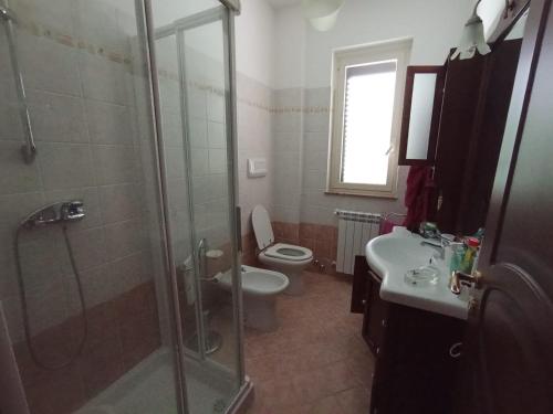 a bathroom with a shower and a toilet and a sink at Villa Framaca in Furnari