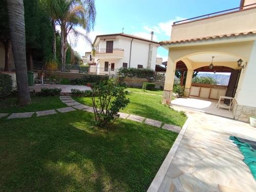 a backyard with a pool and a house at Villa Framaca in Furnari