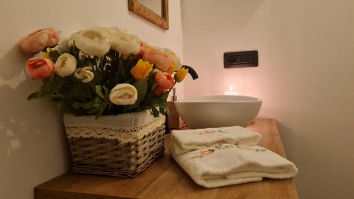 een vaas met bloemen op een tafel met handdoeken bij Casa delle rondini in Cingia deʼ Botti