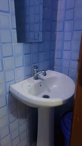a bathroom with a white sink and a mirror at L&A Homes in Kisii