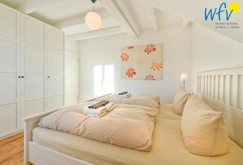 una camera da letto bianca con un letto grande di Landhaus Ostdüne Ferienwohnung Dünenmeer a Juist