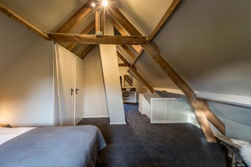 a attic bedroom with a bed and a vaulted ceiling at Wien's Villa Veluwe in Hoenderloo