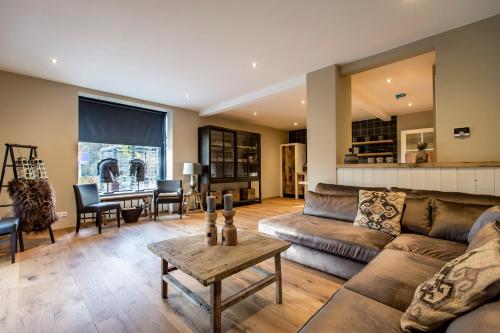 a living room with a couch and a table at Wien's Villa Veluwe in Hoenderloo