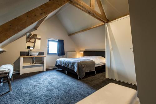 Schlafzimmer im Dachgeschoss mit einem Bett und einem Fenster in der Unterkunft Wien's Villa Veluwe in Hoenderloo