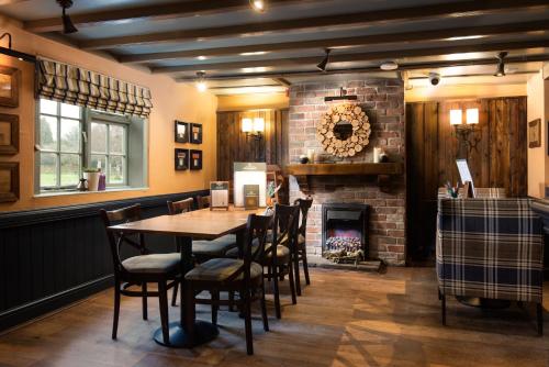 a dining room with a table and a fireplace at The King's Head Inn - The Inn Collection Group in Great Ayton
