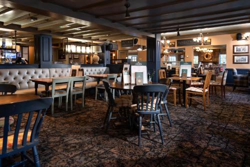 a dining room with wooden tables and chairs at The King's Head Inn - The Inn Collection Group in Great Ayton
