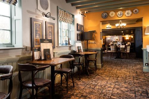 a bar with tables and chairs in a restaurant at The King's Head Inn - The Inn Collection Group in Great Ayton