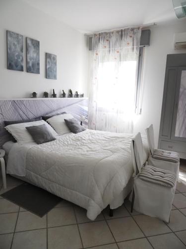 a white bedroom with a large bed and a window at La Mandragola Garden in Berra