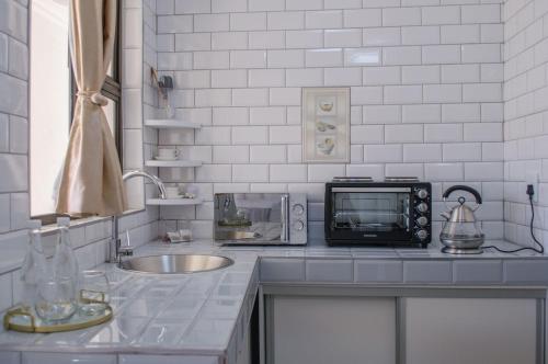 a kitchen counter with a microwave and a sink at Shark Island Guesthouse in Lüderitz