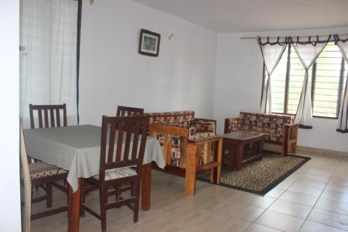 a dining room with a table and chairs at Gemini Villas in Kijiwetanga