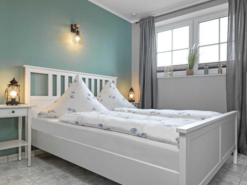 een slaapkamer met een wit bed met kussens bij Poeler Haihappen im FIP in Insel Poel