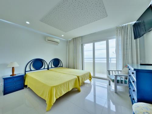 Ένα ή περισσότερα κρεβάτια σε δωμάτιο στο Apartamentos Turisticos Perola da Rocha