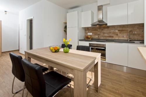 a kitchen with a wooden table and black chairs at Hvar sea view apartment in Hvar