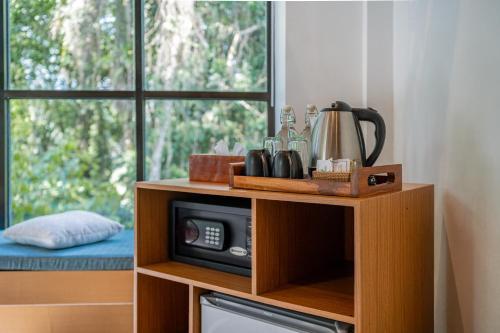 a microwave on a wooden stand next to a window at The Nani in Ubud