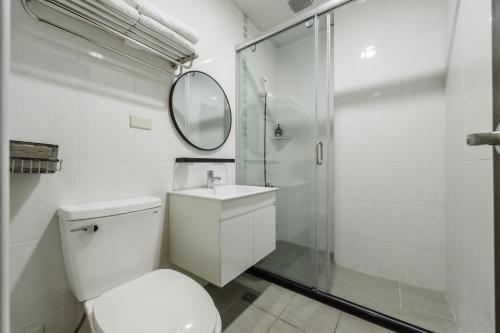 花蓮市的住宿－迴藝行旅-簡約風格民宿，一间带卫生间、水槽和镜子的浴室