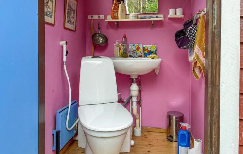 a pink bathroom with a toilet and a sink at Amazing Home In Hrryda With Sauna in Härryda