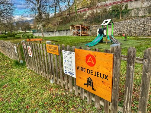 a fence with signs on it with a playground at Grand Mobile-Home 6 Places climatisé in Munster