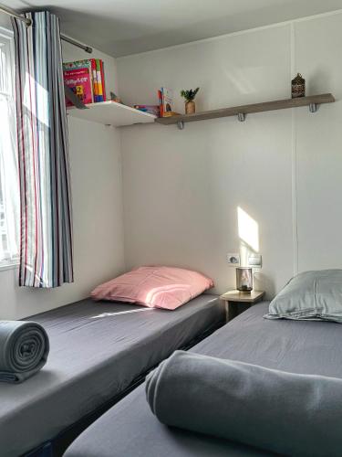 two beds sitting next to each other in a room at Grand Mobile-Home 6 Places climatisé in Munster