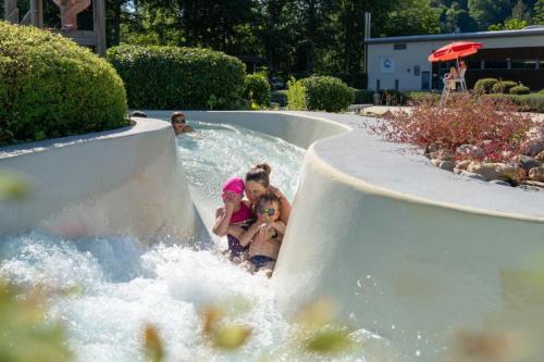 a group of children playing in a water slide at Grand Mobile-Home 6 Places climatisé in Munster