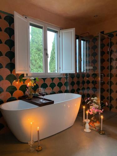 a large bathroom with a white tub and candles at Villa Lena in Palaia