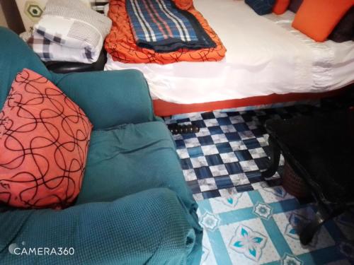 a bedroom with a bed and a couch and a bed at Cosy budget Single room in Nairobi