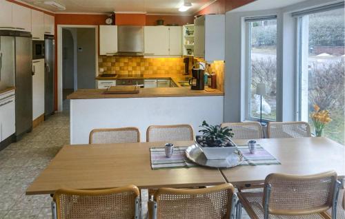 バルデマーシュビークにあるAmazing Home In Valdemarsvik With Wifiのキッチン(テーブル、椅子、カウンター付)