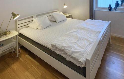 a bed with white sheets and pillows in a bedroom at Amazing Home In Valdemarsvik With Wifi in Valdemarsvik