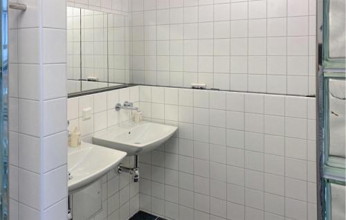 a white tiled bathroom with two sinks and a mirror at Amazing Home In Valdemarsvik With Wifi in Valdemarsvik