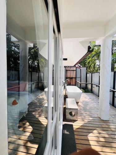 a bathroom with a tub and a sink on a balcony at Mrs. Swan Hotel in Ban Hin Chang (2)