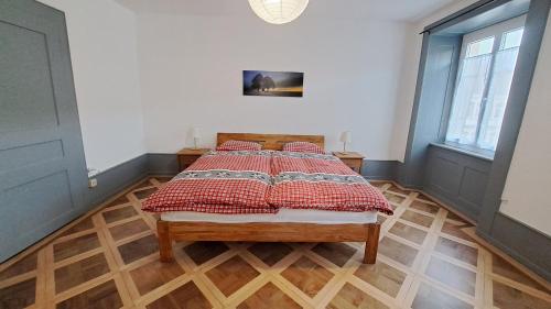 Schlafzimmer mit einem Bett mit roten und weißen Kissen in der Unterkunft Appartement de vacances Les Jardins in Saint-Imier