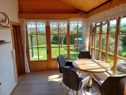 a room with a table and chairs and large windows at Ferienhaus Kumpitsch in Sankt Johann im Saggautal