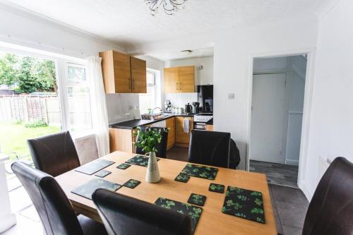 Il comprend une cuisine et une salle à manger avec une table et des chaises en bois. dans l'établissement Probert- Perfectly Placed- Driveway - 3 bed, à Wolverhampton