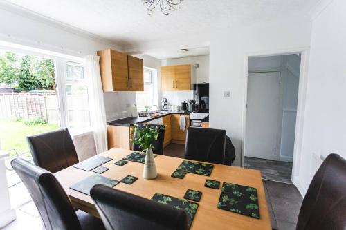 a kitchen and dining room with a wooden table and chairs at Probert- Perfectly Placed- Driveway - 3 bed in Wolverhampton