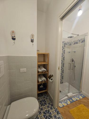 ein Bad mit einer Dusche und einem WC in der Unterkunft il faro di serapide in Neapel