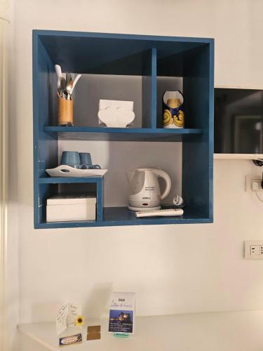 a blue shelf on a wall with items on it at il faro di serapide in Naples