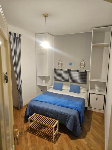 a bedroom with a large bed with blue sheets at il faro di serapide in Naples