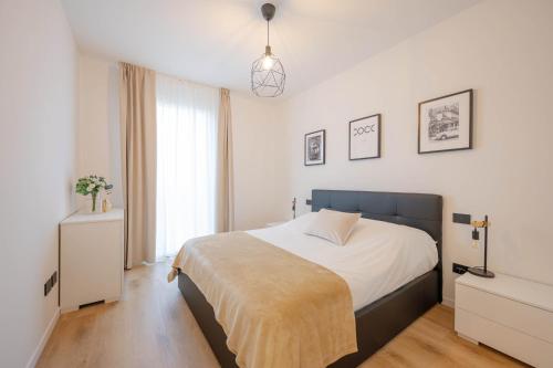 ein Schlafzimmer mit einem Bett und einer Hängeleuchte in der Unterkunft Resminik Home in Lido di Jesolo