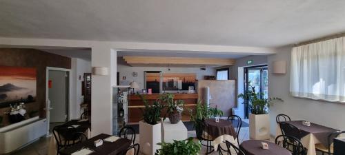 a dining room with tables and chairs and a kitchen at Hotel I Platani in Siena