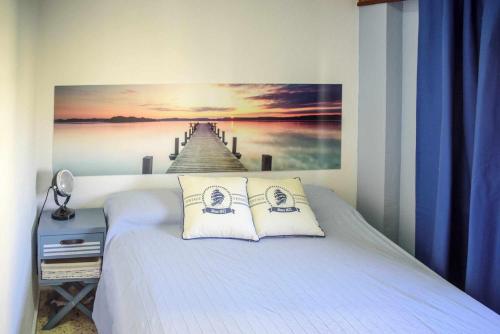 ガンディアにあるApartamento gandiaziar premiumのベッドルーム1室(桟橋の絵画付)