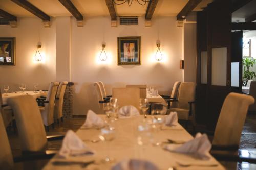 un comedor con mesas, sillas y luces en Hotel Marshal, en Nikšić