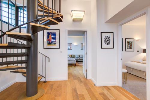 a hallway with a spiral staircase in a house at The Hoover Building by Artsy in London