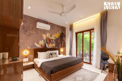 カルジャットにあるStayVista's The Isabella House - Hill-View Villa with Outdoor Pool & Pool-Side Gazeboのベッドと壁に絵が飾られた寝室